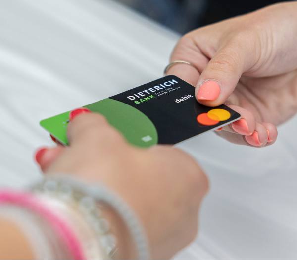 A debit card is being exchanged between two people.