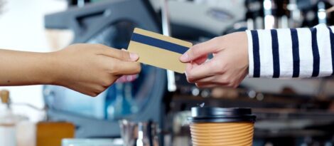 A person passes a credit card to a retail clerk.