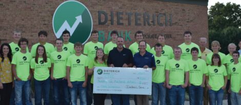 Dieterich bank employees in bright green shirts pose outside a branch while holding a large check made out to CTEC.