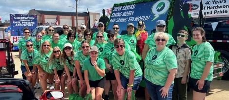 Large group of Dieterich Bank employees standing in front of the Super Saver super hero themed float.