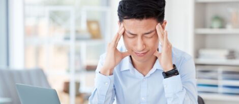 stressed looking man rubbing his temples.