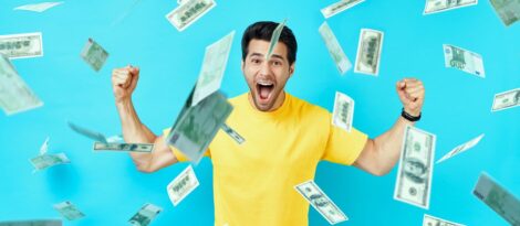 Robin's egg blue background, excited man in yellow shirt with money falling around him