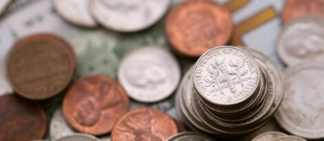 Close-up of U.S. coins and paper currency representing savings, budgeting, and personal financial habits.