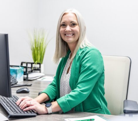 Female-banker-smiling-and-typing-on-computer